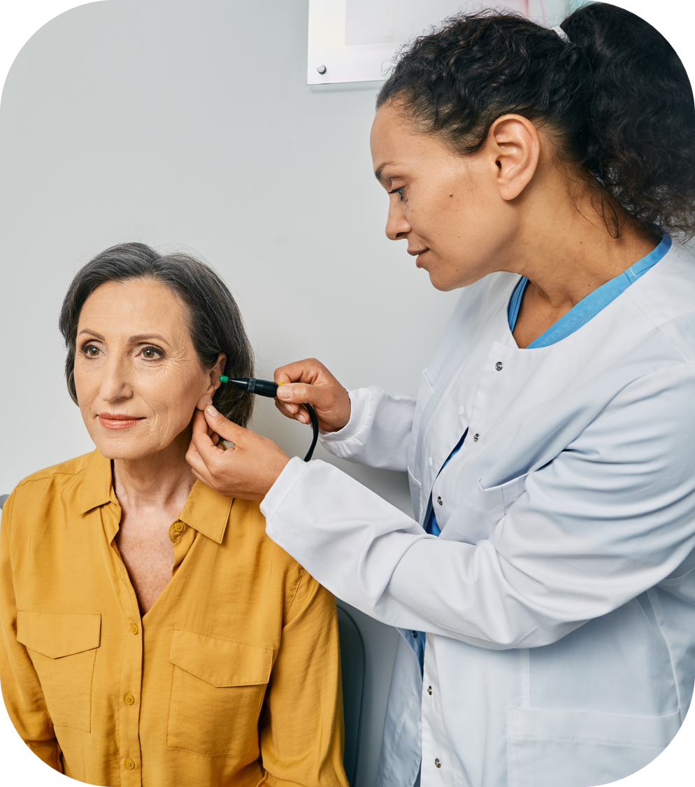 Audiologist examining a patient's ear with an otoscope